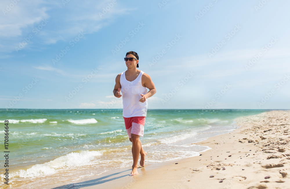 happy man running along summer beach happy man running along summer beach