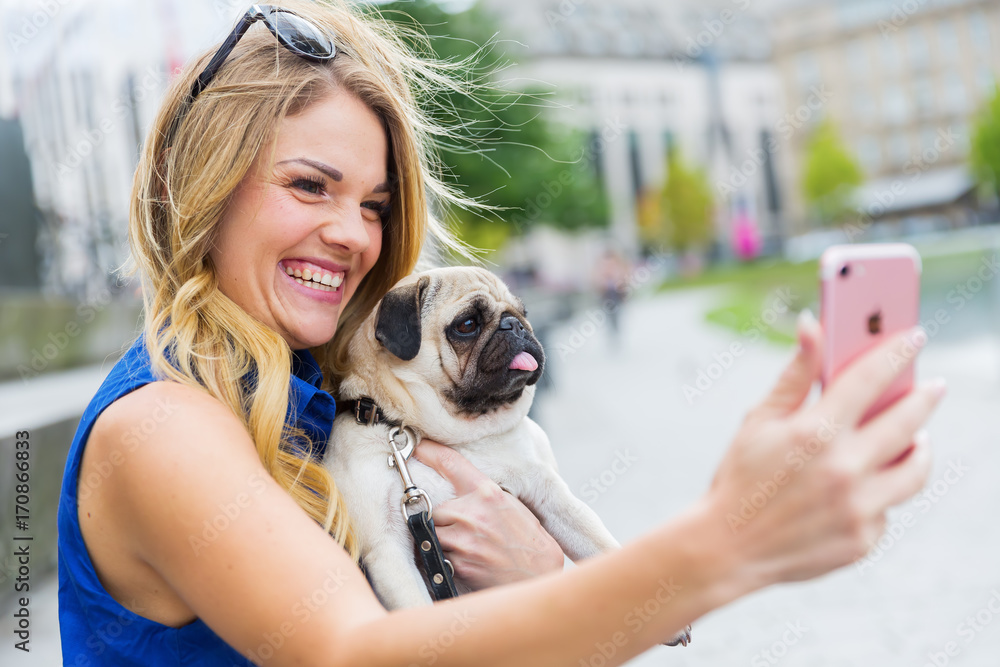 young woman with a pug makes a selfie
