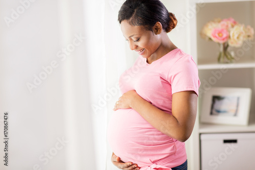happy pregnant woman with big belly at home