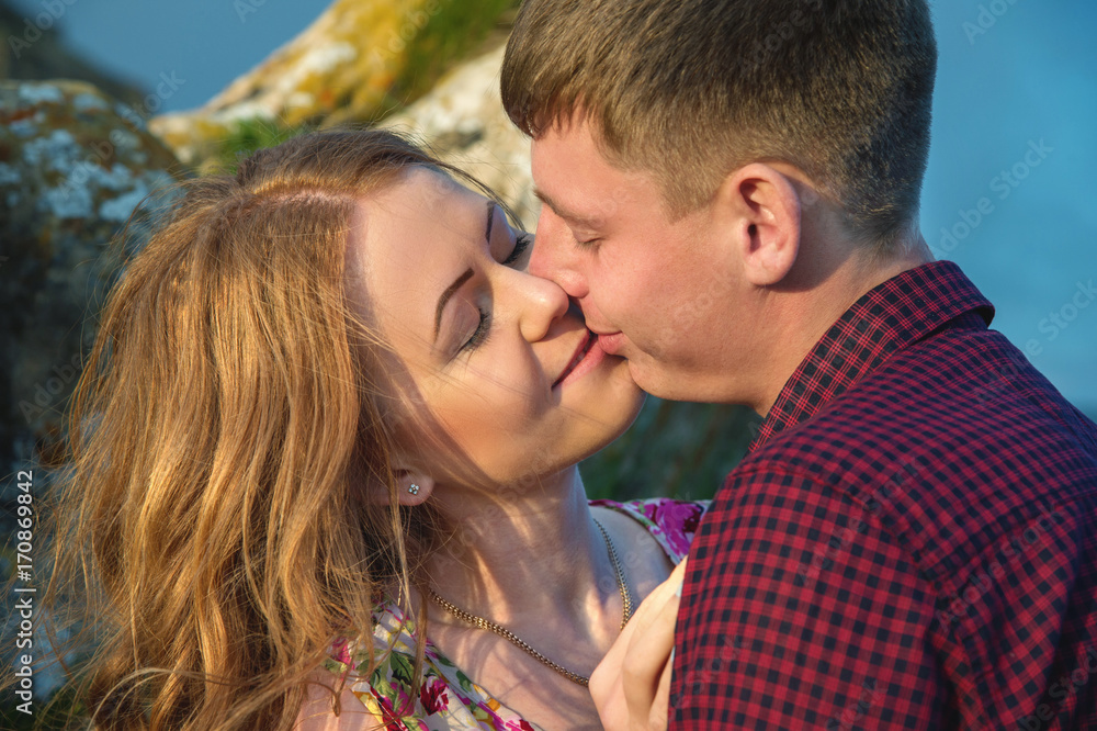 Young happy couple kissing on nature against the beautiful Caucasian landscape. Young happy couple kissing on nature against the beautiful Caucasian landscape.
