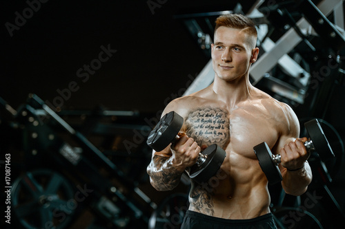 Handsome model young man working out in gym