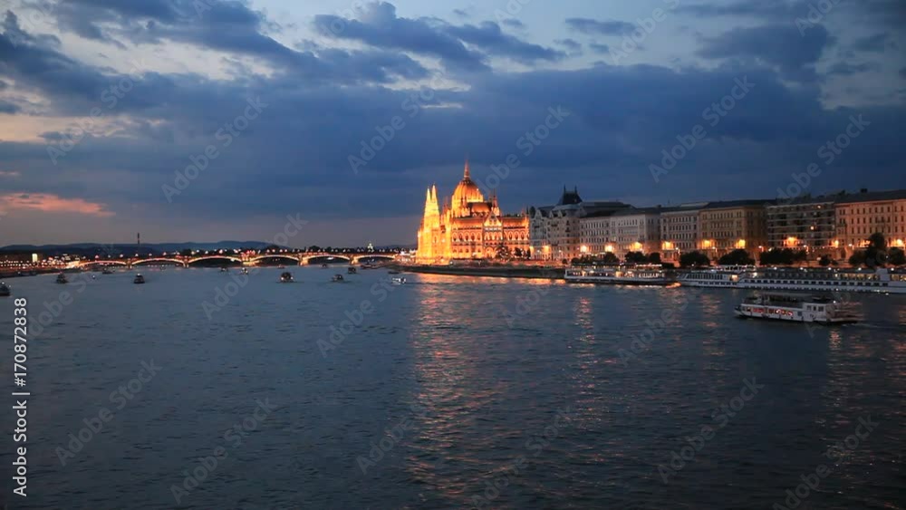 The picturesque landscape of the Parliament in Budapest, Hungary after the sunset. Cruise ships crossing the Danube river. The picturesque landscape of the Parliament in Budapest, Hungary after the sunset. Cruise ships crossing the Danube river.