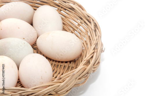 raw dirty duck eggs in basket on white background