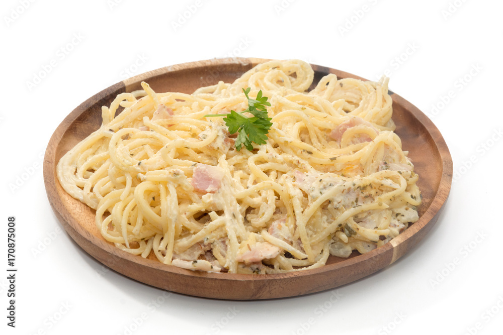 spaghetti carbonara with cream on wooden plate on white background spaghetti carbonara with cream on wooden plate on white background