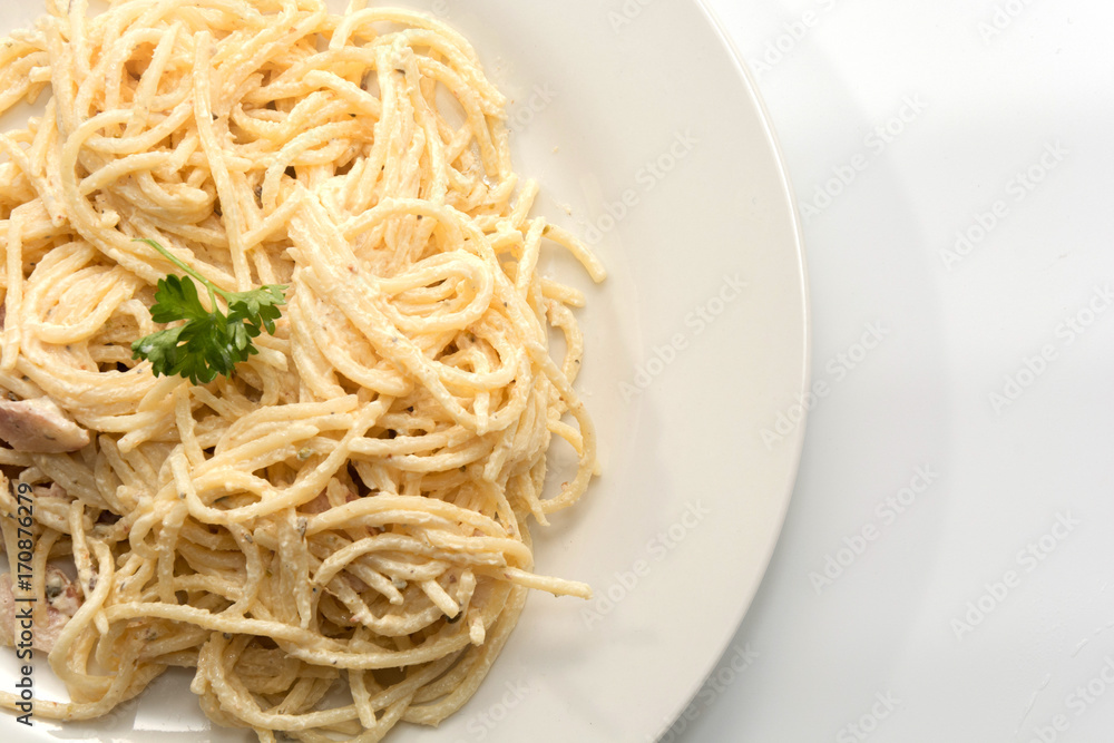spaghetti carbonara with cream on white plate