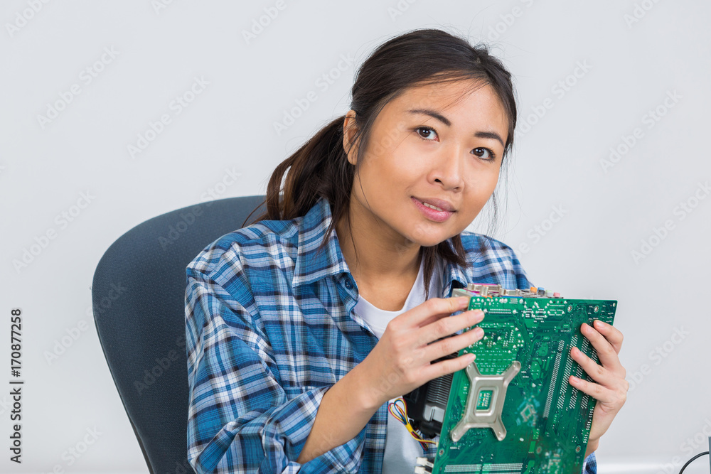 female technician soldering mother board of computor female technician soldering mother board of computor
