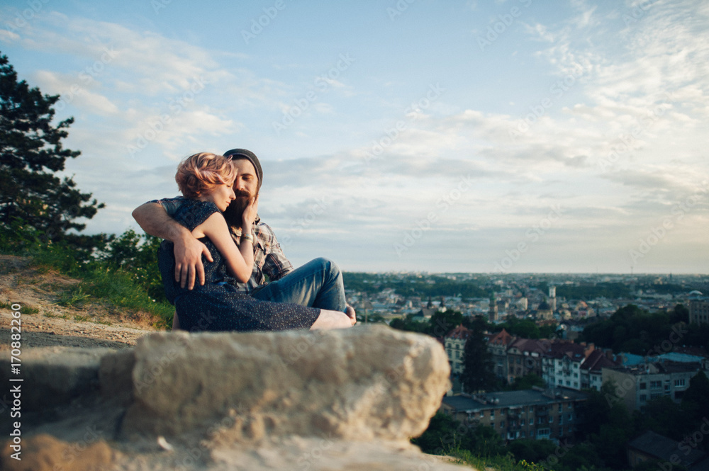traveler couple sitting on edge of mountain