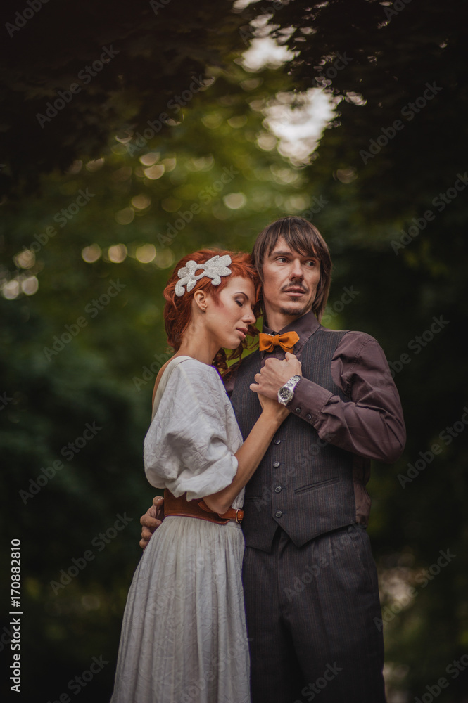 Obraz premium romantic couple hugging on blurred green forest background