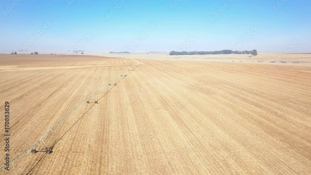 Center pivot irrigation rig stands on dry field aerial shot Center pivot irrigation rig stands on dry field aerial shot