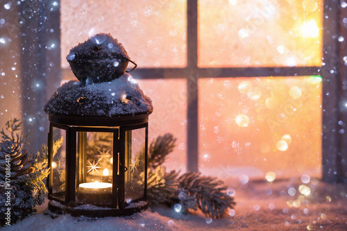 Winter decoration with a candlestick near the snow-covered window