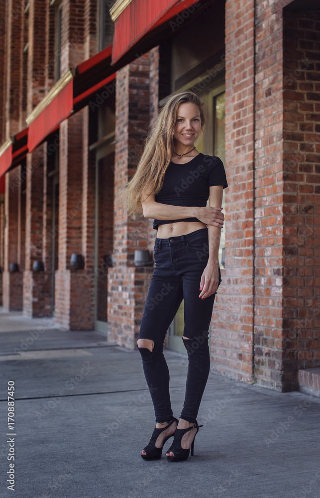 Beautiful thin young woman in black jeans and t-shirt