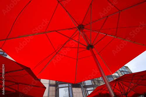 Three red patio umbrellas as seen from bottom. Cafe umbrellas filling frame close up