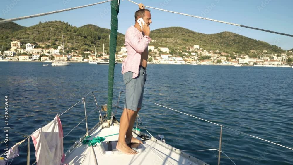 Young man talking on cellphone while sailing boat on sea
Young man talking on cellphone while sailing boat on sea