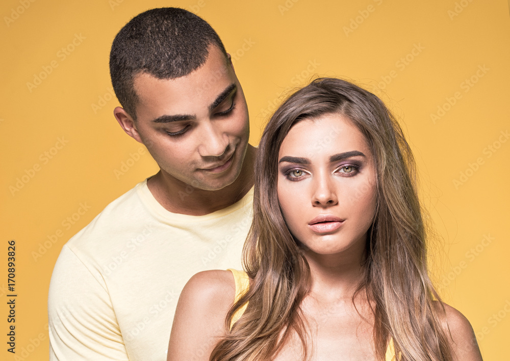 Beautiful couple posing on yellow background. Beautiful couple posing on yellow background.