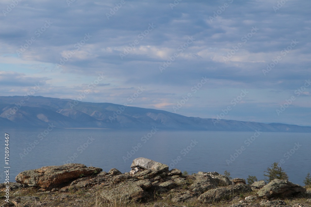 Rocks in steppe with a lake in the background near lake Baikal, Russia, June 2017