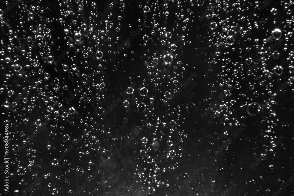 Rain drops on the glass on a black background