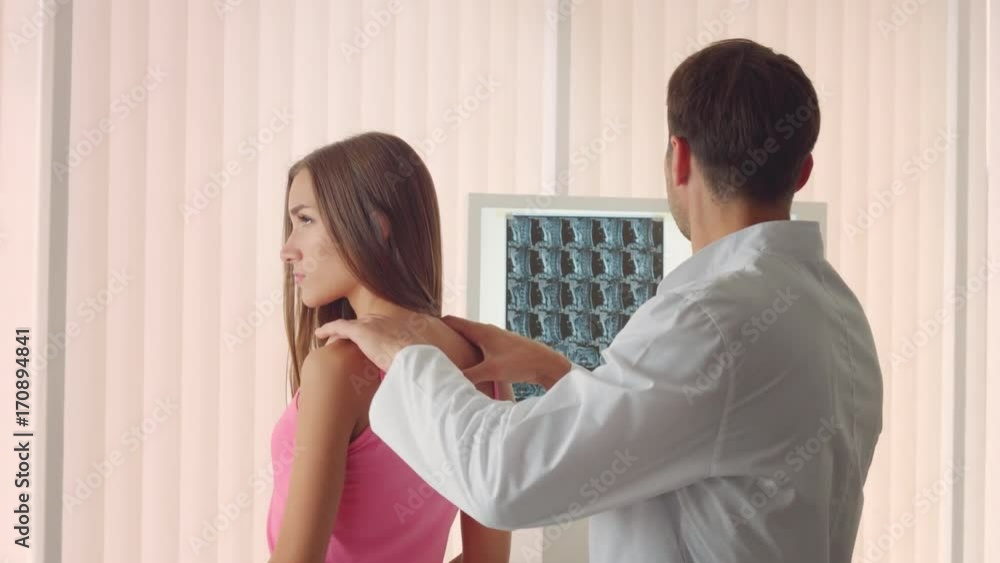 Male doctor examines the female patient's back Male doctor examines the female patient's back