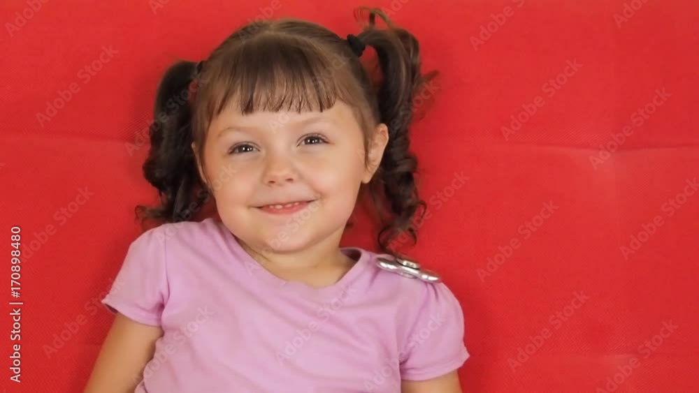 A spinning spinner on the child's shoulder. Beautiful little girl and grains with a spinner. A spinning spinner on the child's shoulder. Beautiful little girl and grains with a spinner.