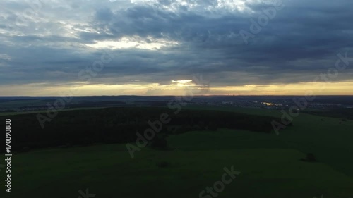 View from drone field with sunset sky nature landscape background. Footage. Aerial view of rural area with forest road in summer sunset photo