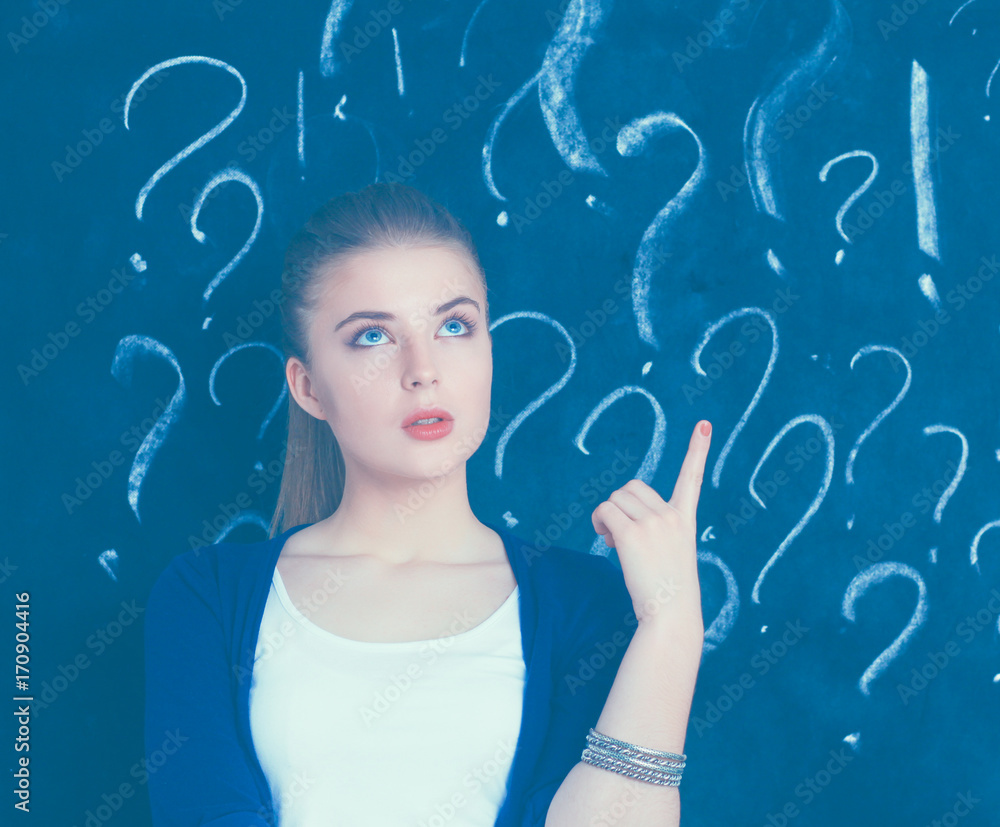 Young girl with question mark on a gray background Young girl with question mark on a gray background
