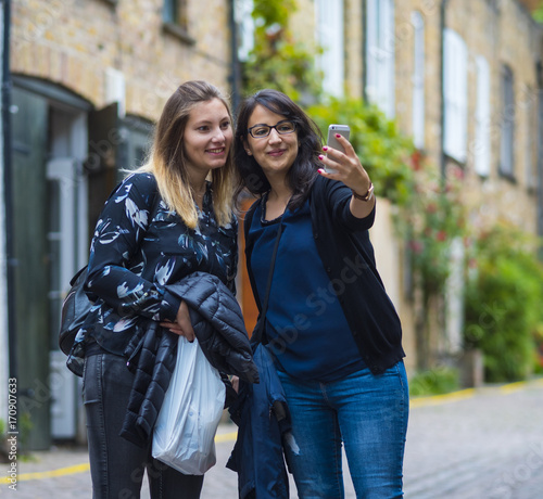 Girls make selfies during a city trip to London