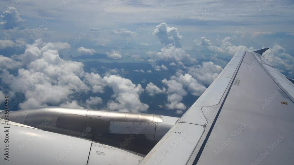 A view from the airplane window over the wings and engines. The planes are flying above the clouds and sky in transportation or travel concept. A view from the airplane window over the wings and engines. The planes are flying above the clouds and sky in transportation or travel concept.