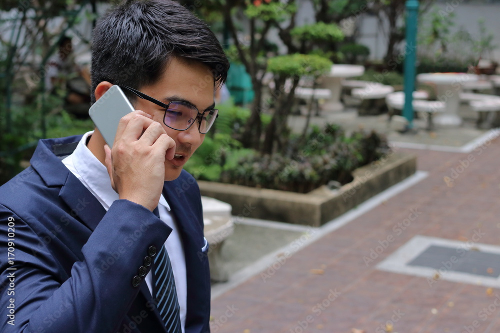 Handsome buinessman talking on his mobile phone in city park. Handsome buinessman talking on his mobile phone in city park.