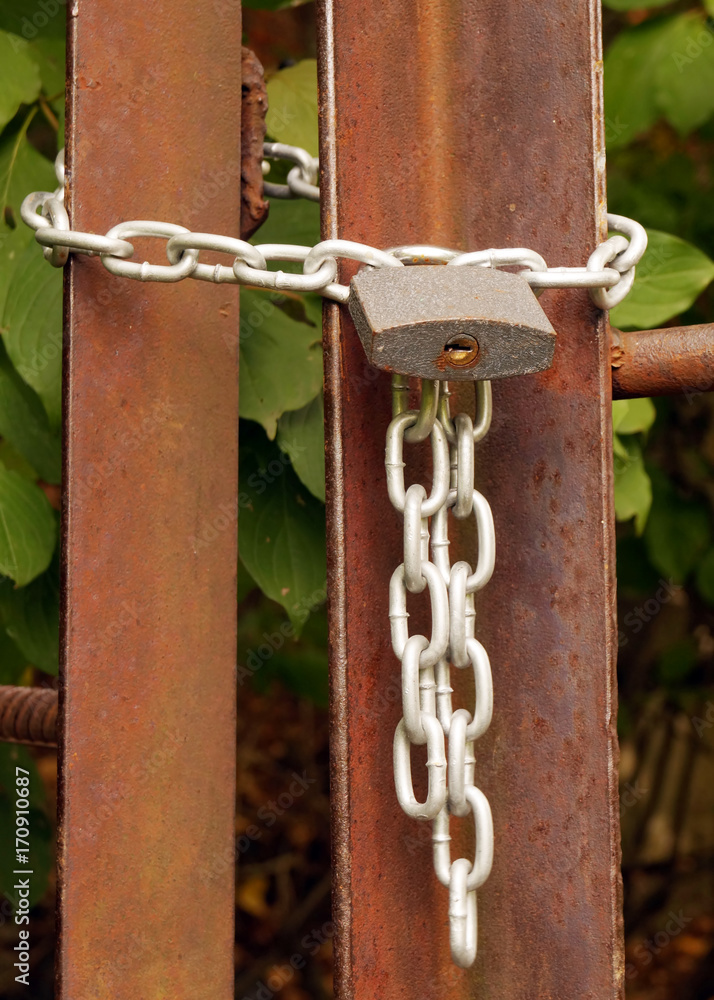 Padlock on the metal chain, locking the entrance.