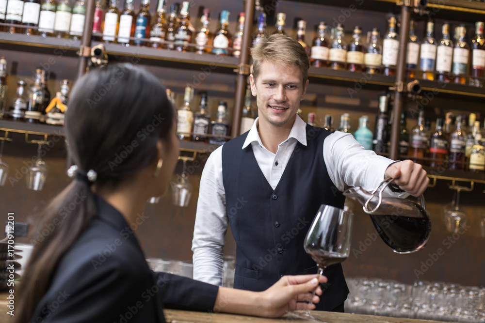 Bartender serving Wine to Customer at counter, Bartender enjoy to serving Wine for Customer, People Lifestyle Concept.