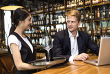 Asian Woman Waiter serving Wine to Customer with Happy Emotion in restaurant, People Working at restaurant Concept.