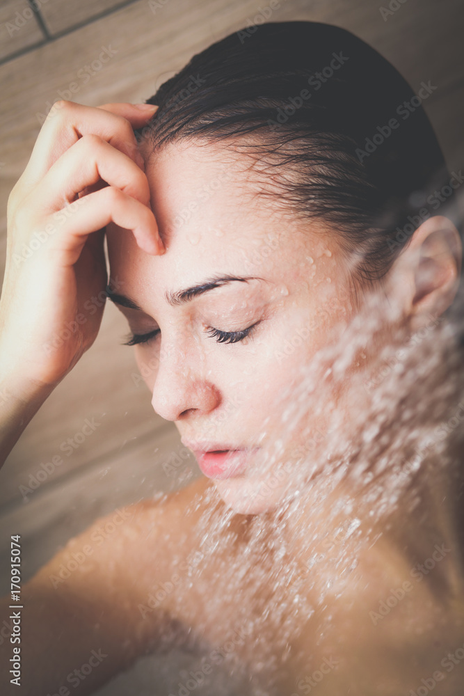 Naklejka premium Young beautyful woman under shower in bathroom.