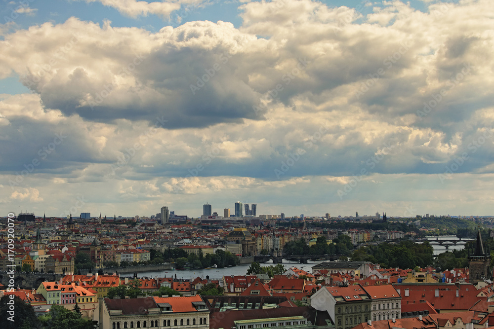 Panorama view of Prague skyline with bridges and Vltava river in the cloudy summer day.
