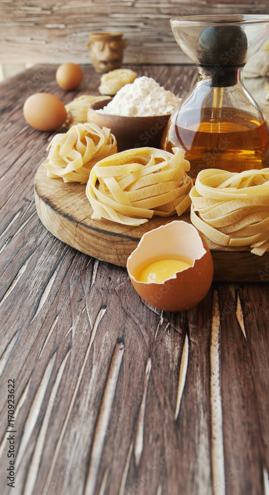 Uncooked pasta with flour on the table, selective focus Uncooked pasta with flour on the table, selective focus