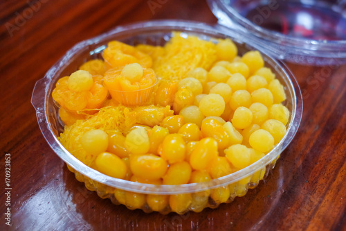 Dessert set consists of golden drops (egg yoke fudge balls cooked in syrup / thong yot), bean-paste, golden threads (foi thong), golden flowers (thong yip) in clear box - Thailand dessert concept.
