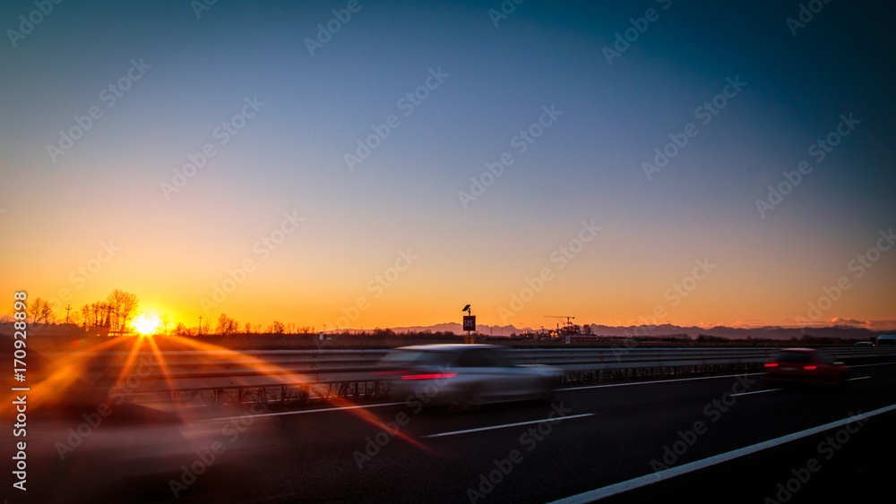 Fototapeta premium sun goes down behind an industry