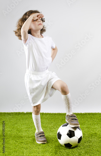 Boy with soccer ball on a gray background. Back view © kravik93
