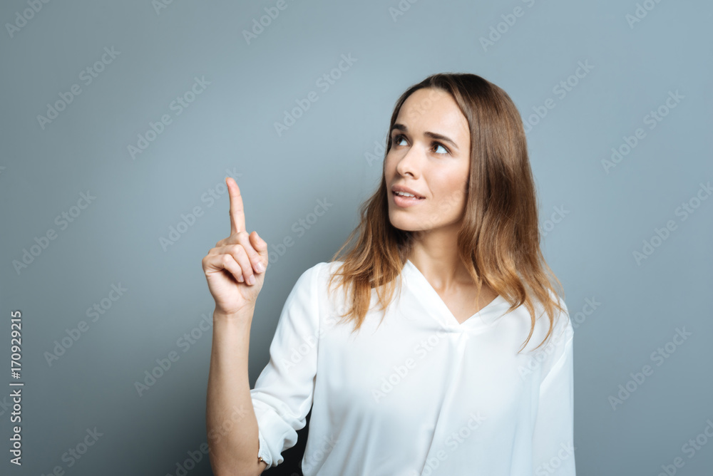 Attractive young woman pointing up with her finger Attractive young woman pointing up with her finger