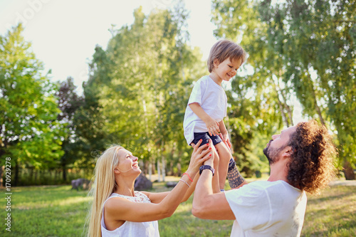 Happy family playing with a child in the park. © Studio Romantic