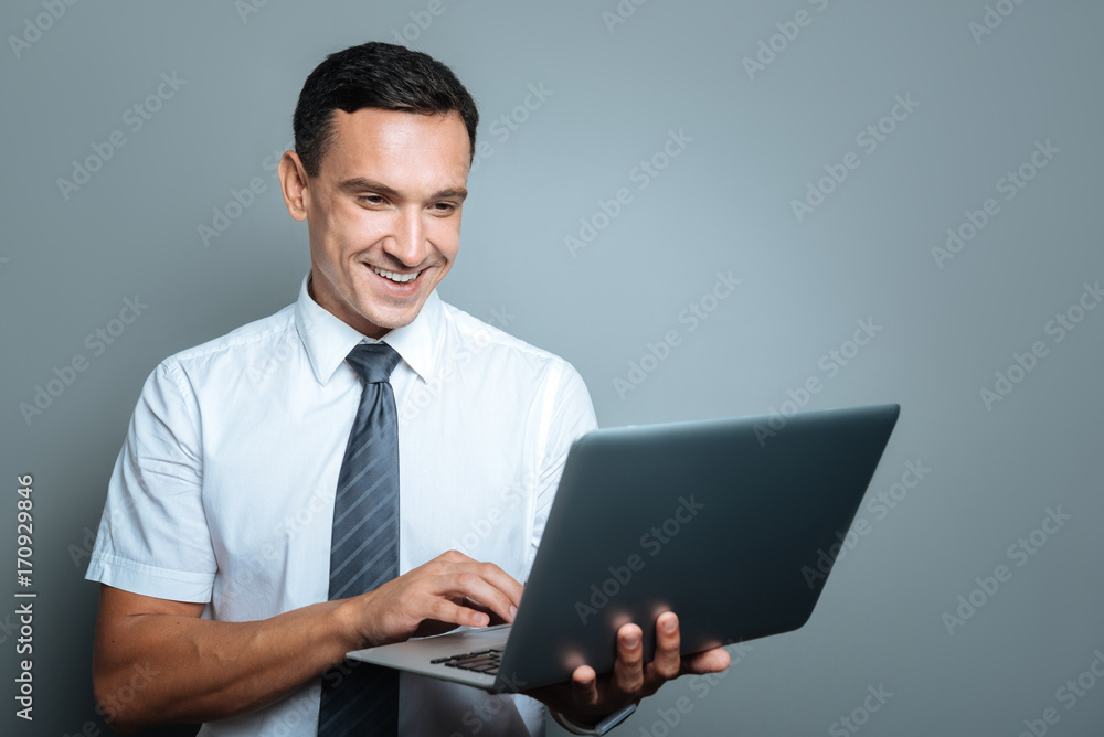 Cheerful young manager working on a laptop Cheerful young manager working on a laptop
