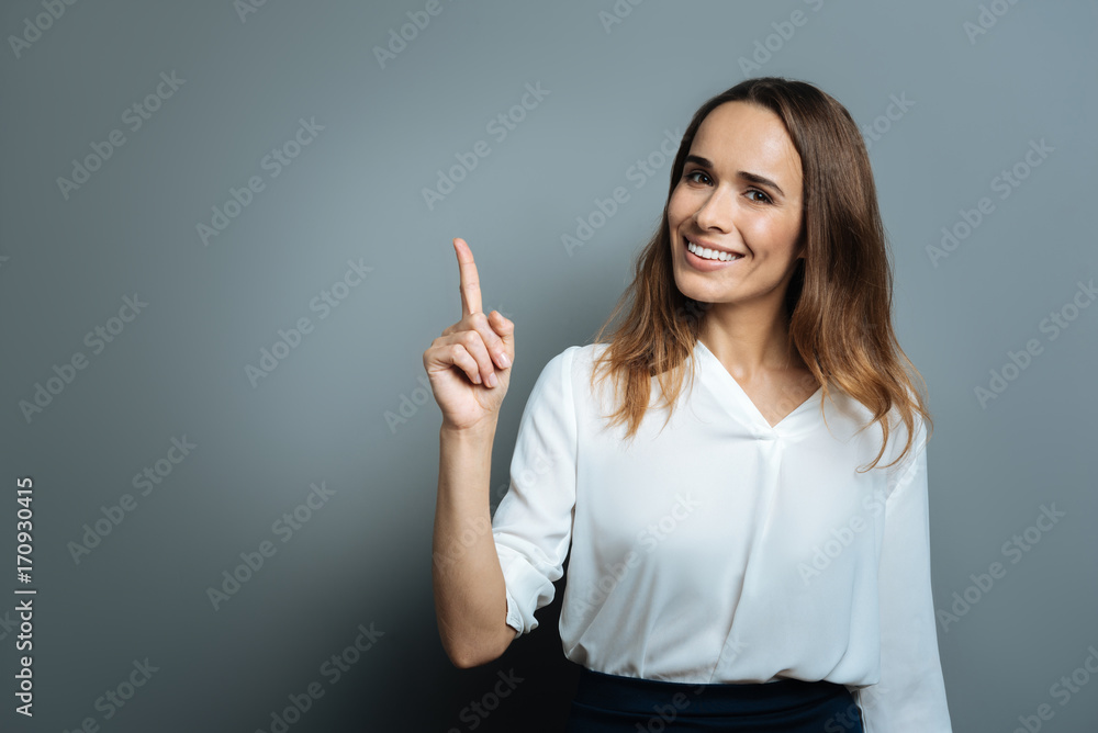 Joyful happy woman pointing up with her finger Joyful happy woman pointing up with her finger