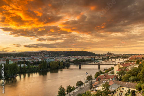 Prague sunset over Vltava river from above with orange sky.