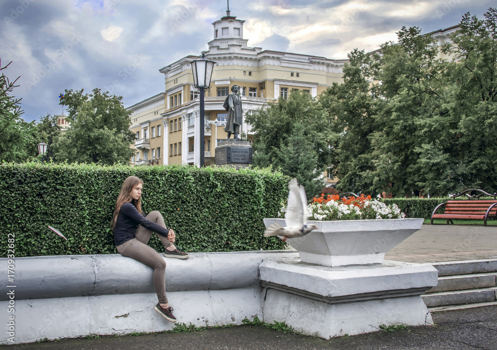 Wight girl sitting on street and dreaming while bird flying away