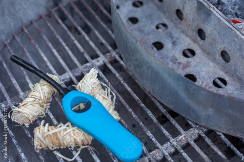 Holzwolle Grillanzünder und Feuerzeug liegen auf Grillrost neben  Kohleschalen im Kugelgrill Stock-Foto | Adobe Stock