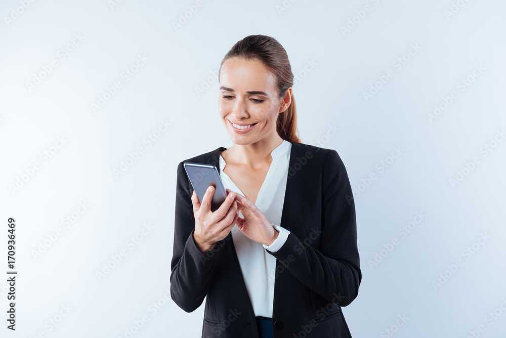 Positive happy woman looking at her smartphone screen Positive happy woman looking at her smartphone screen