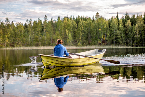 Finnland, leben im Mökki, auf einer Insel die nur mit dem Ruderboot zu erreichen ist. Der nächste Ort Juvola ist 1 km entfernt. Region Linnansaari Nationalpark, Mann rudert über den See