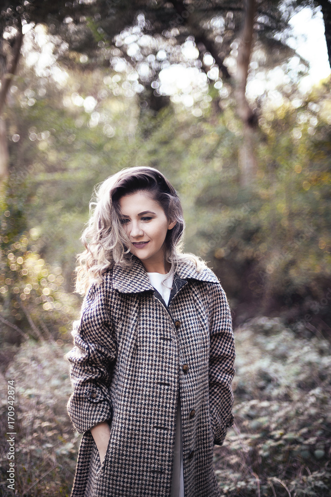 Young blond female portrait outdoors in Tirana Grand Park. Autumn look: beige wool coat. Young blond female portrait outdoors in Tirana Grand Park. Autumn look: beige wool coat.