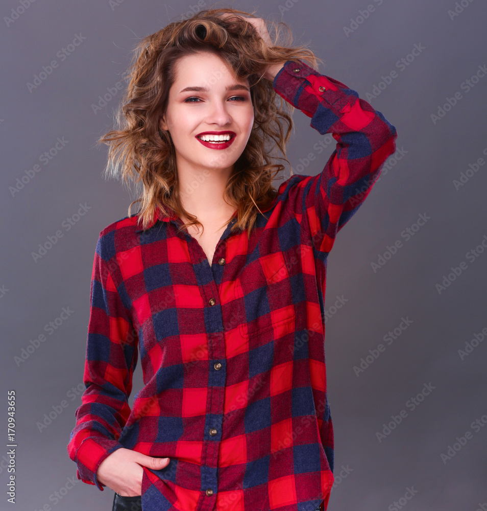 Young woman standing, isolated on gray background Young woman standing, isolated on gray background