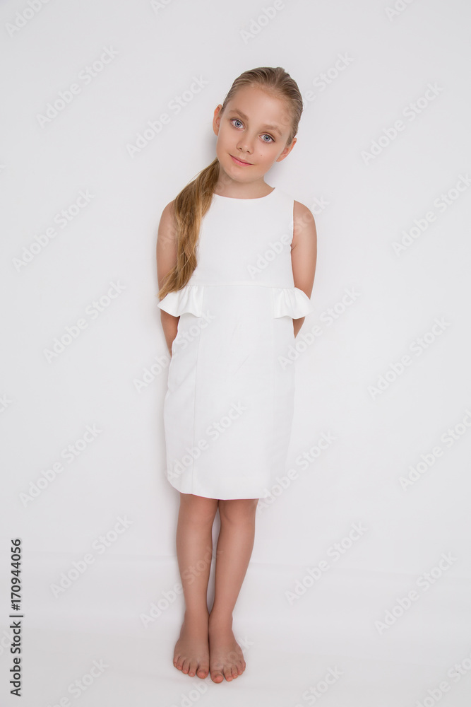 Beautiful blonde young model, cute girl, in white dress on a white  background. Elegant little girl Stock Photo