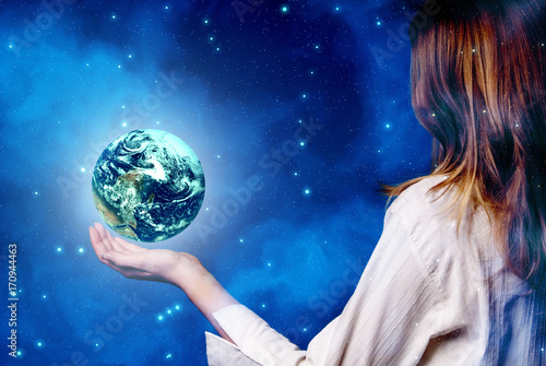 The planet Earth in a hand of young woman like a concept of ecology, future, religion and love, 