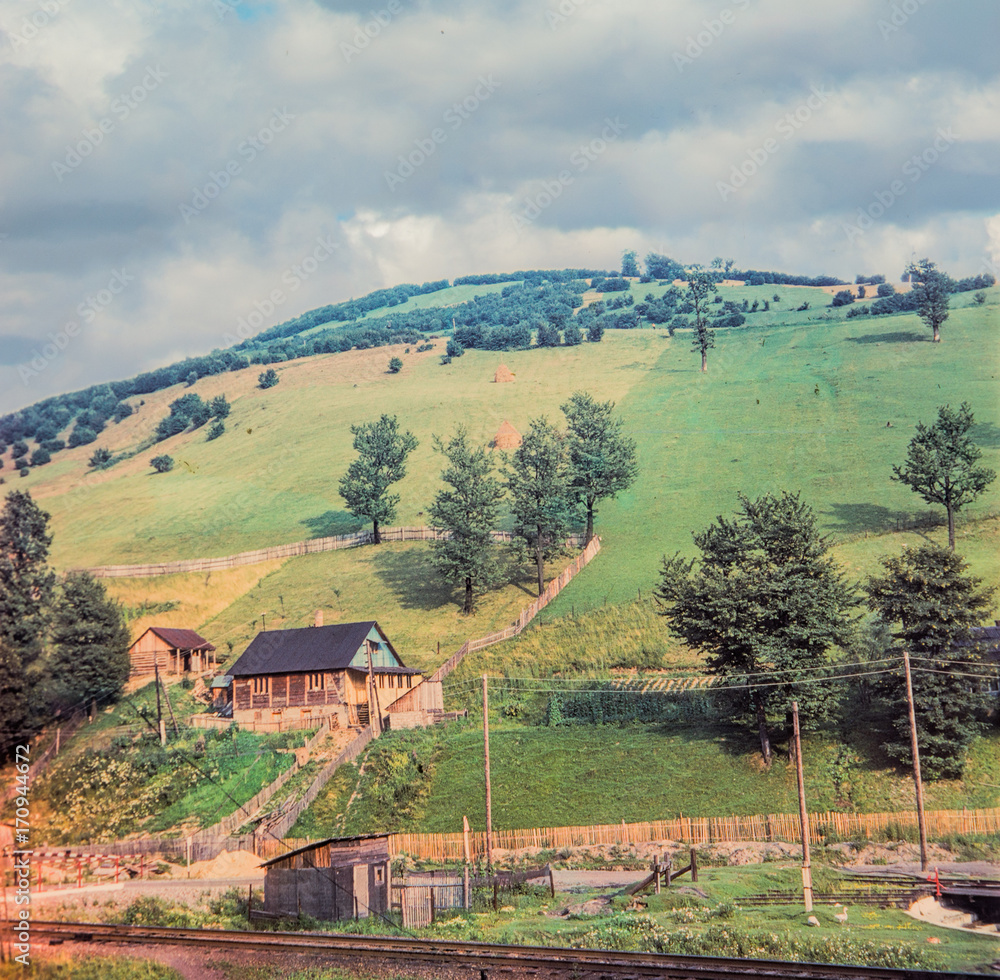 Naklejka premium House under the mountain near the railway